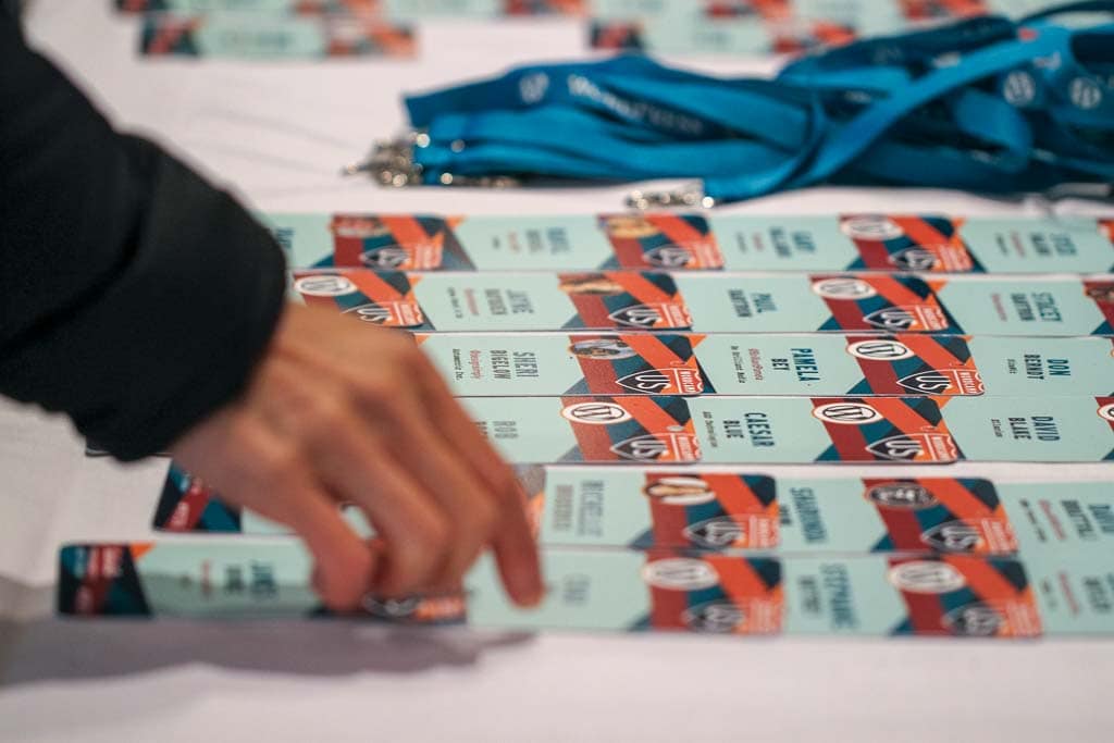 Colorful name badges lie on a table for attendees to pick up.