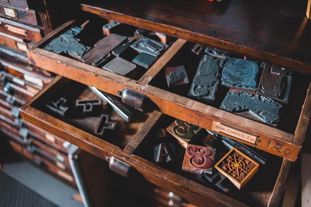 Various print blocks in drawers, ready to be used in a printing press.