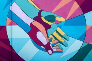 A colorful painted mural of hands reaching out.