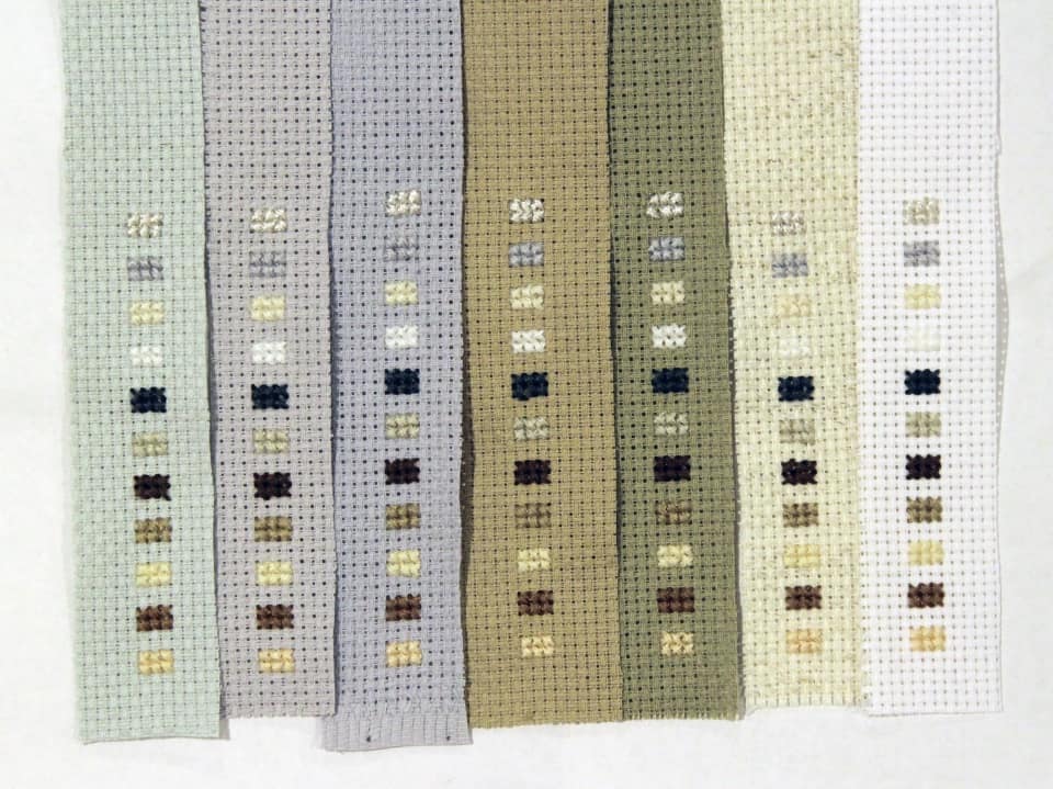 Different colors of thread swatched on various background cloths