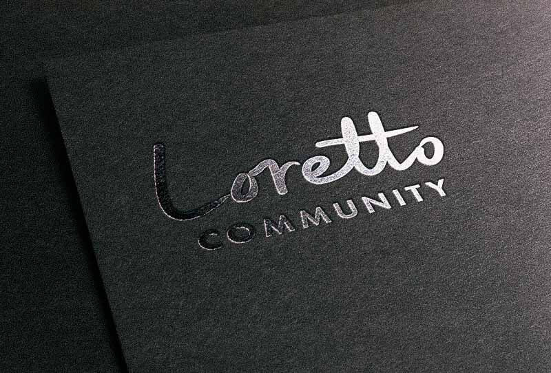 Loretto logo embossed on black paper