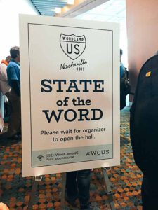Large sign has WCUS logo and says "State of the Word"